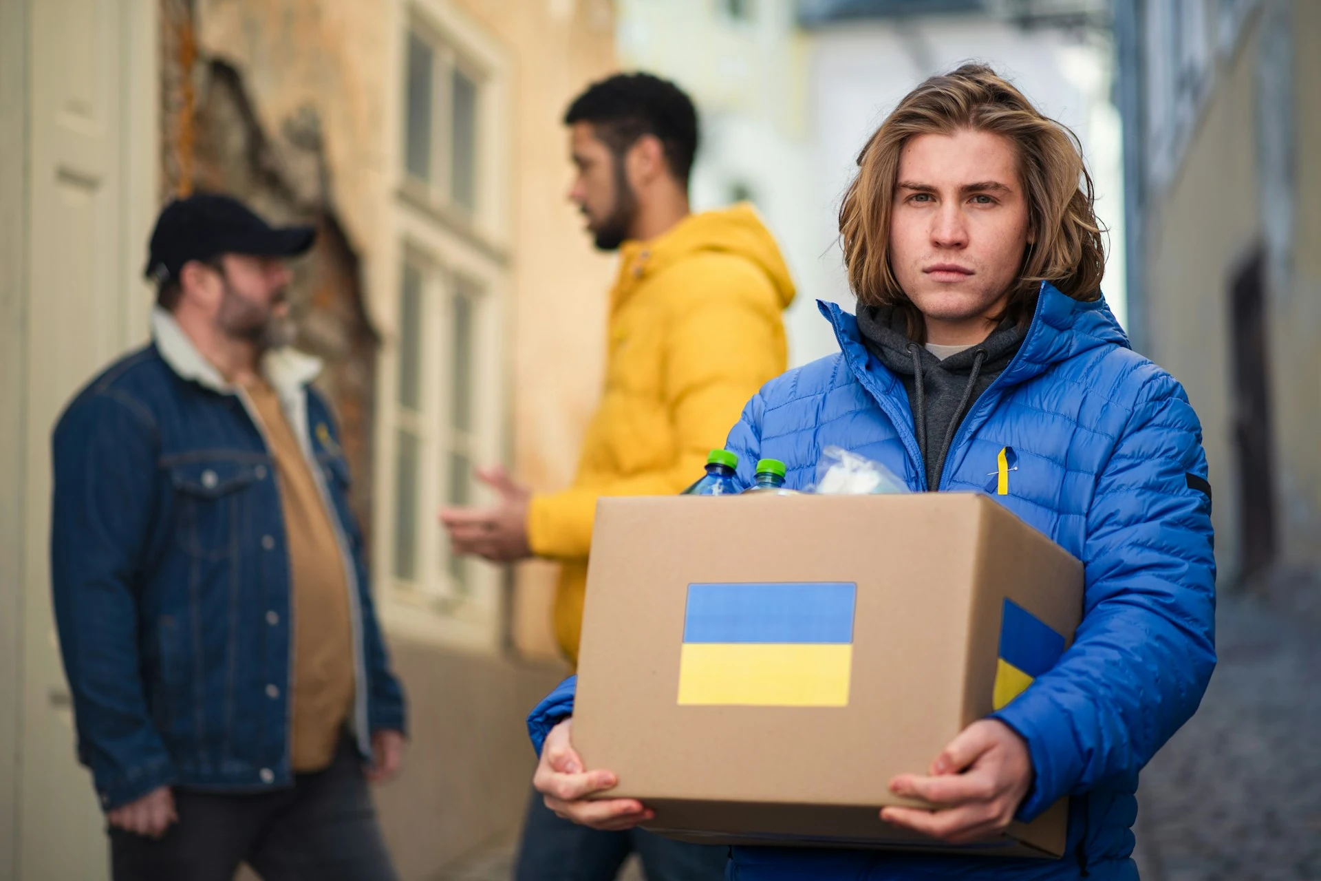 Volontari distribuiscono scatole di aiuti con la bandiera ucraina